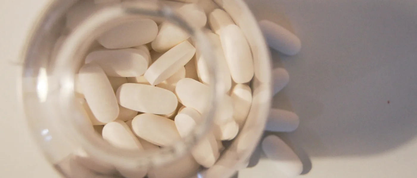Weisse Tabletten in einem Glas, von oben gesehen