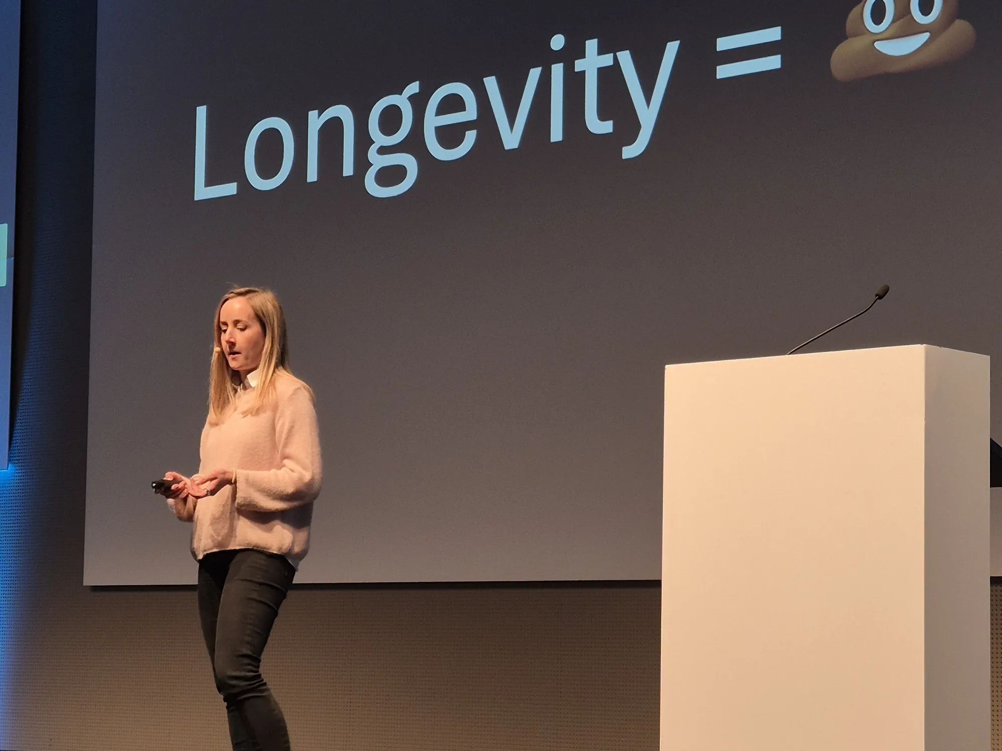 Jelina Linder spricht auf der Bühne, hinter ihr die Folie Longevity